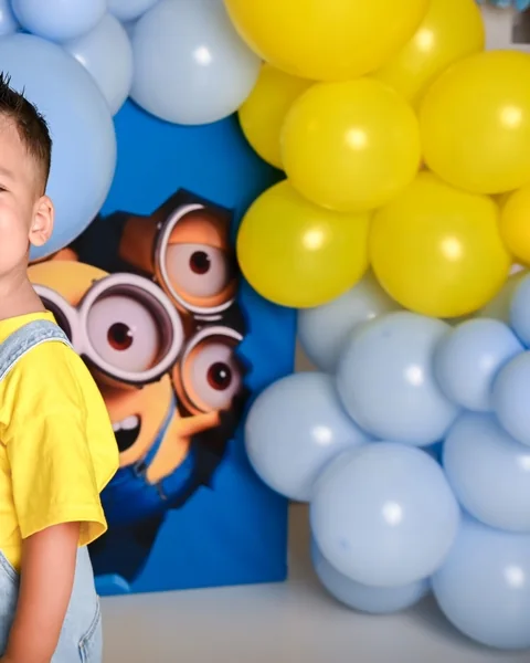 Niño en un set de Minions con globos de colores