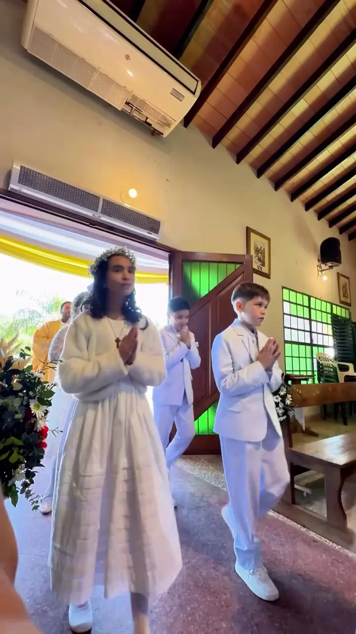 Niños de primera comunión con sus velas en la iglesia